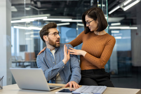 Colleagues interact in office showcasing courtship dynamics with elements of workplace. Woman...