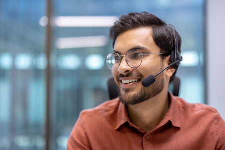 Hispanic businessman smiling during office call with headset on, indicating positive communication...