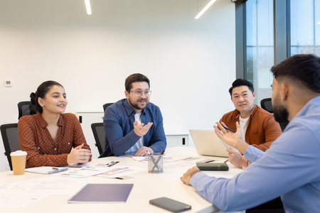 Diverse business team engaged in a meeting, discussing ideas and strategies around a table in a...
