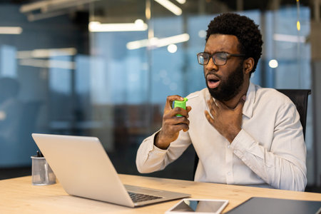 Man in a bright office environment using a throat spray to alleviate pain. The image communicates...