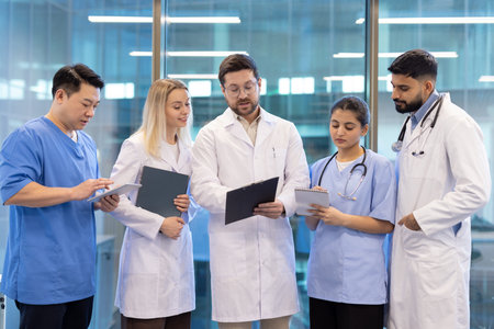 Doctors and nurses examining medical records and discussing a patients treatment plan in a modern...