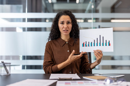 Businesswoman presenting a negative financial report, showing concern over the economic downturn and...