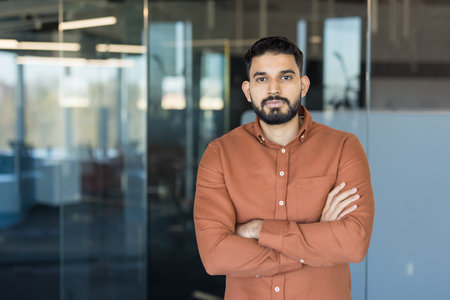 Confident indian business professional or entrepreneur standing with arms crossed, portraying a...