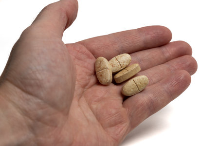 Pills in a man hand isolated on white background. Tablets in a hand of humanの写真素材
