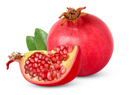 Pink pomegranate with cut in a chunk with green leaves isolated. Ripe pomegranates with clipping path and leaf.の写真素材