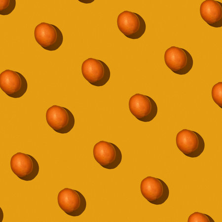 Fresh juicy whole orange on yellow background. Fruit pattern, summer concept. Flat lay Top view. Background with citrus fruitsの写真素材