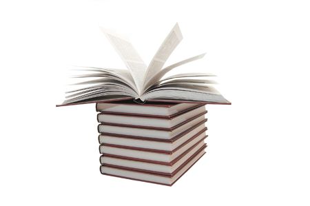 pile of books with one book open on white backgroundの写真素材