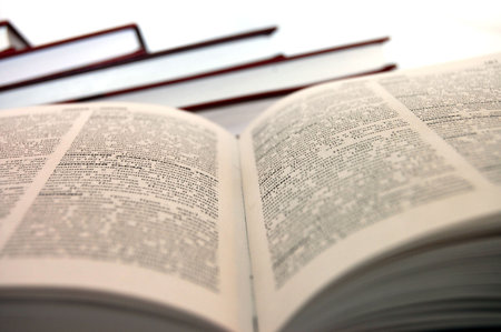 An open book against white background. , most of the text is thrown out of focus and is not...