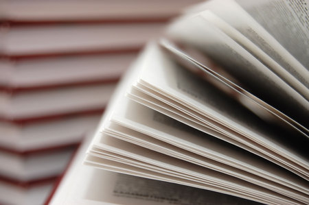 Fragment of the open book against other books