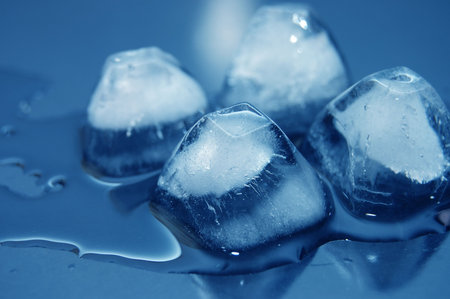 colored ice cubes melted in water on reflection 
