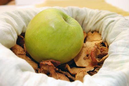 Green apple on pieces of dry applesの写真素材