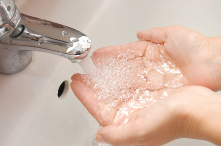 woman washing hand under running 
