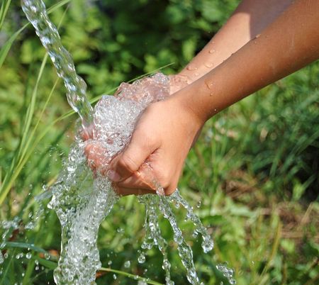 Hands catching clean falling water close upの写真素材