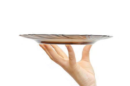Empty glass plate in a female hand , isolated on white backgroundの写真素材