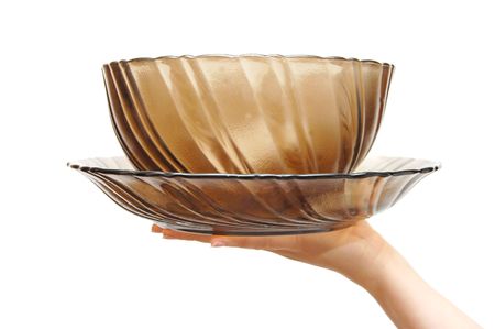 Empty glass dish in a female hand, isolated on white backgroundの写真素材