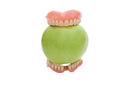 Dentures with green apple, isolated on a white backgroundの写真素材