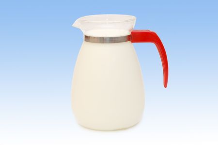 Glass jug of milk isolated on blue backgroundの写真素材
