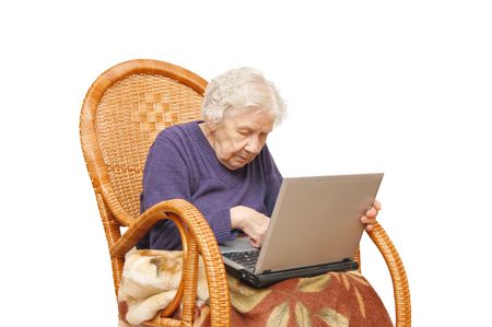 Grandmother with the laptop in an armchairの写真素材