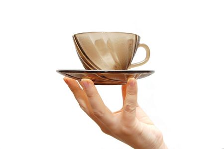  Empty glass cup with a saucer in a female hand, isolated on white backgroundの写真素材