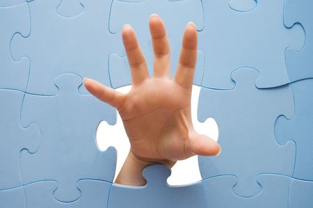 Female hand through a puzzleの写真素材