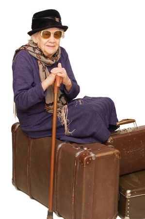 The old lady sits on a suitcaseの写真素材