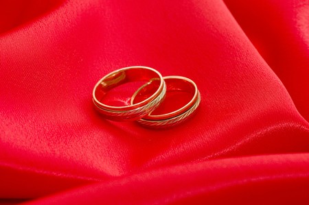 Two gold wedding rings on the redの写真素材