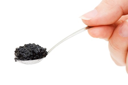 Black caviar on a spoon isolated on whiteの写真素材