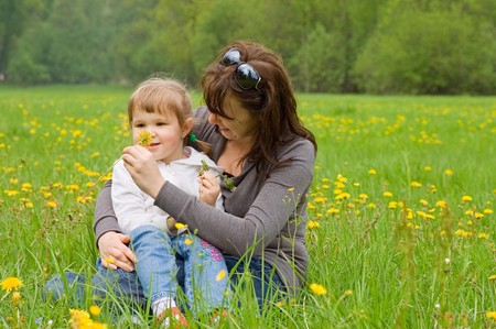 Mum with a daughter collect dandelionsの写真素材