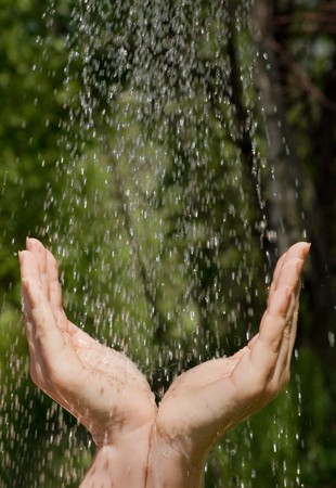 Hands catching clean falling water close up の写真素材