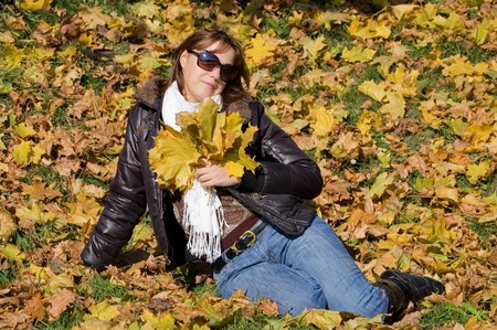 The beautiful girl with autumn leavesの写真素材