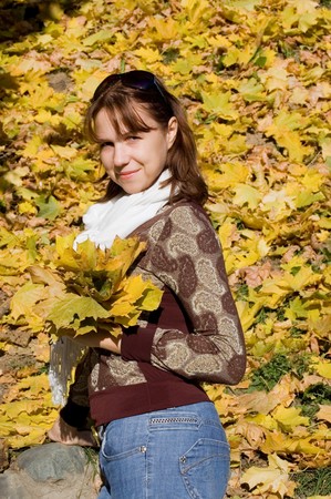 The beautiful girl with autumn leavesの写真素材