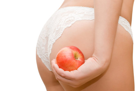 Female buttocks and apple in a hand