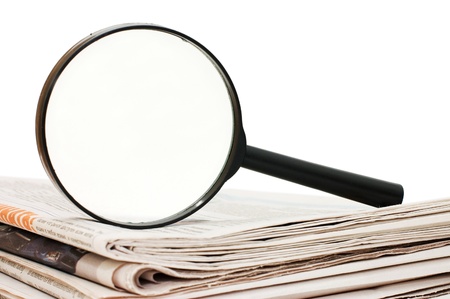 Magnify glass over a stack of newspaperの写真素材