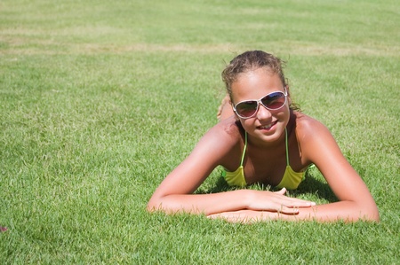 The young girl lays on a grassの写真素材