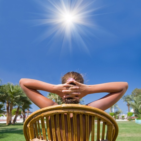 The girl sits in an armchair on a grass の写真素材