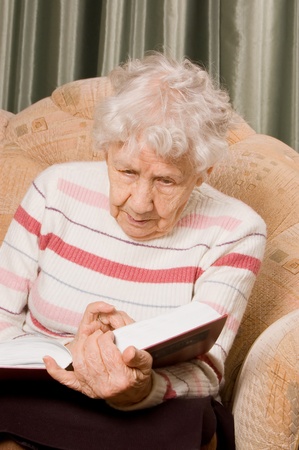 The elderly woman reads the bookの写真素材