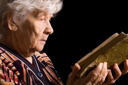 The elderly woman reads the bookの写真素材