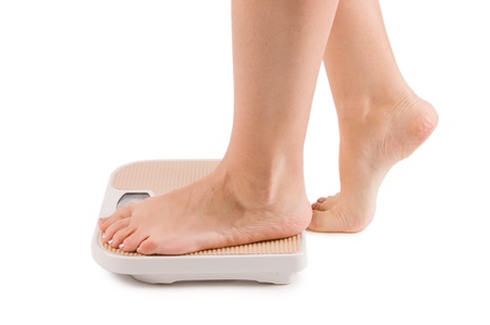 Female feet on scales isolatedの写真素材