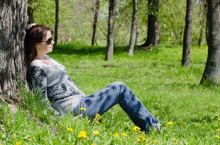 The beautiful girl at a tree in the summerの写真素材