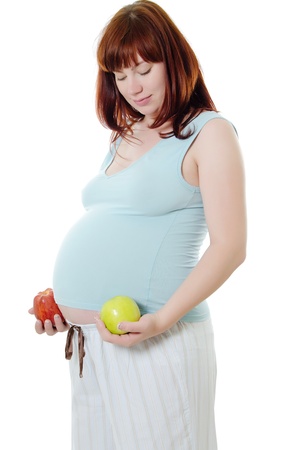 The pregnant woman with an red apple and a green apple isolatedの写真素材