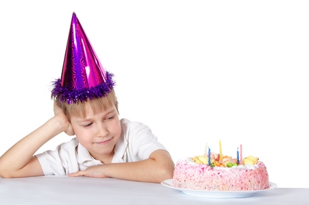 Boy in a party hat with a birthday cake.の写真素材