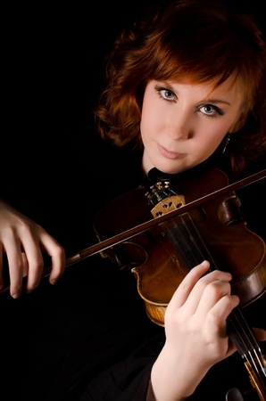 The beautiful woman plays violin on blackの写真素材