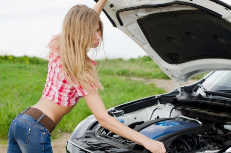 The beautiful girl repairs the carの写真素材