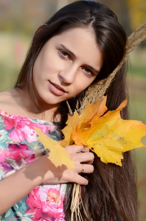 The beautiful young girl in autumn parkの写真素材