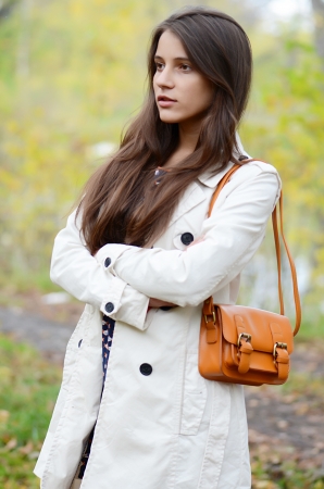 The beautiful young girl in autumn parkの写真素材