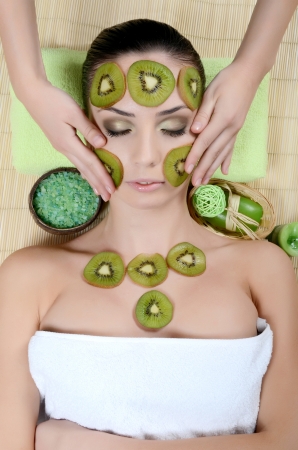 Girl with mask from kiwi on faceの写真素材