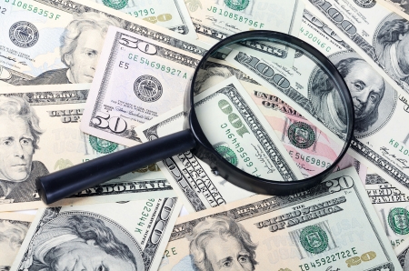 The magnifying glass lying on banknotes close-upの写真素材