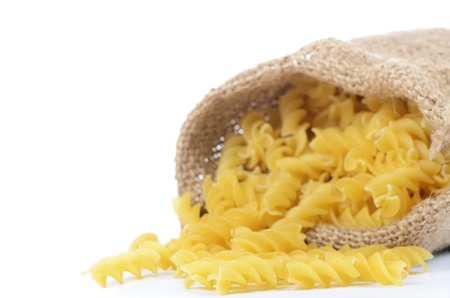 Spiral pasta in sack isolated on whiteの写真素材