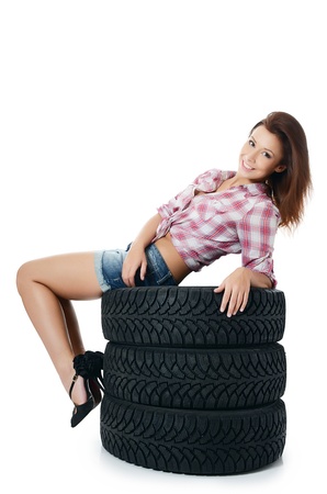 Girl with automobile tyres isolated on whiteの写真素材