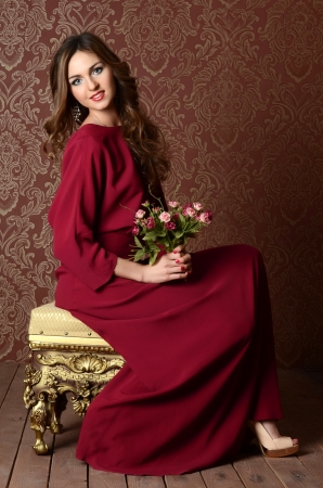 Elegant sensual young woman in claret dressの写真素材